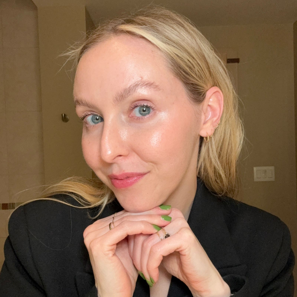 beauty director of Allure Sarah Kinonen poses for picture in black blazer and glowy skin