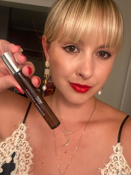 Allure senior beauty editor Paige Stables holding a bottle of the Nest New York Balinese Coconut Perfume Oil